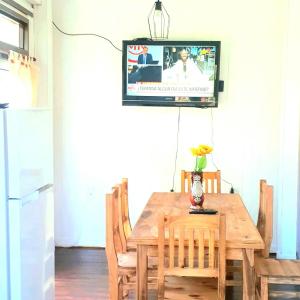 mesa de comedor con TV en la pared en Arco iris en Tigre