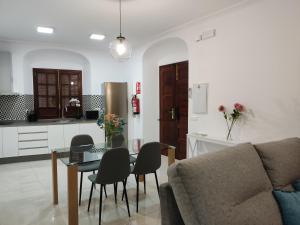 ein Wohnzimmer mit einem Sofa und einem Tisch sowie eine Küche in der Unterkunft Apartamentos BARBAS in Villanueva de los Castillejos
