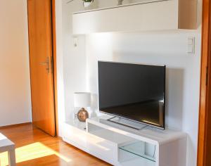 a flat screen tv sitting on a white entertainment center at Messewohnung Düsseldorf - Neuss in Neuss