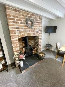 a living room with a brick fireplace with a tv at Cosy 2 bedroom cottage in Llanuwchllyn