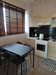 a kitchen with a table and chairs and a stove at Double M comfy flat in Markopoulo