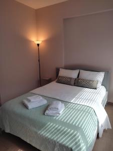 ein Schlafzimmer mit einem Bett mit zwei Handtüchern darauf in der Unterkunft Double M comfy flat in Markopoulo