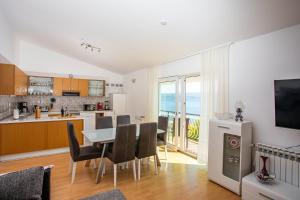 a kitchen and dining room with a table and chairs at Apartments Adisa in Omiš