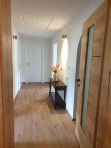 an empty hallway with a table and a door at Panoramablick in Breitenwang