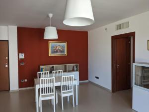 comedor con mesa y sillas en La Casa dei Due Mari - large apartment with parking, en Taranto