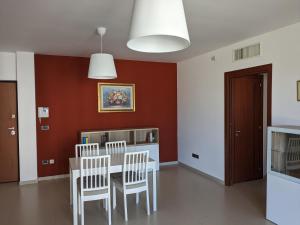 een eetkamer met een tafel en stoelen bij La Casa dei Due Mari - large apartment with parking in Taranto