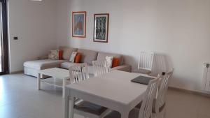 sala de estar con sofá, mesa y sillas en La Casa dei Due Mari - large apartment with parking, en Taranto