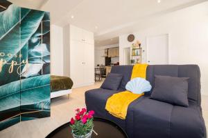 sala de estar con sofá azul y mesa en Le p’tit nid des Halles en Le Grand-Lemps