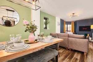 uma sala de jantar com uma mesa e um sofá em Beautiful House in Manchester Sleeps 8 Inc Parking em Wythenshawe