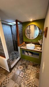 ein Bad mit einem Waschbecken und einer Dusche mit einem Spiegel in der Unterkunft Santerra, Valle de Guadalupe in Valle de Guadalupe