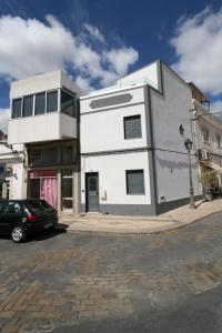 un edificio blanco con un coche aparcado delante de él en Downtown Villa en Faro