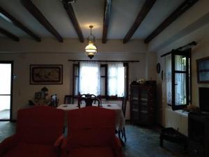 a living room with a table and red chairs at Melina's Mansion in Tsagarada