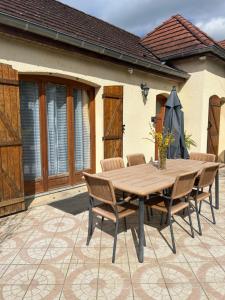 einen Holztisch und Stühle auf einer Terrasse in der Unterkunft La Palmeraie in Saint-Père