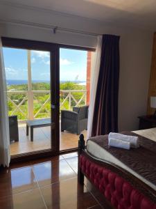 1 dormitorio con cama y vistas a un balcón en Teanehi Bed & Breakfast, en Hanga Roa