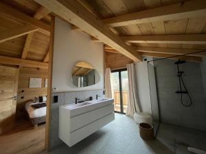 ein Badezimmer mit einem weißen Waschbecken und einer Dusche in der Unterkunft Chalet de Jade in Sallanches