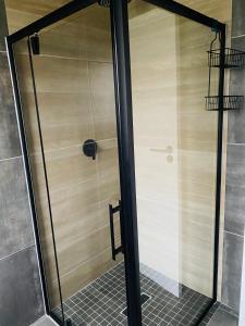 a shower with a glass door in a bathroom at Studio On Nate in Mount Pleasant