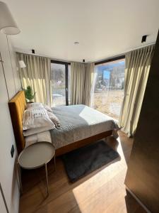 a bedroom with a large bed and a window at The kube by the mountain in Timisul de Jos