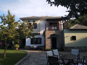 a house with a table and chairs in a yard at Melina's Mansion in Tsagarada