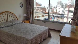 1 dormitorio con cama y ventana grande en Punta Del Este, Península Santos Dumont, 2 dormitorios, 2 baños, 5 personas, en Punta del Este