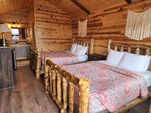 a bedroom with two beds in a log cabin at Bryce Valley Lodging in Tropic