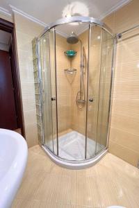 La salle de bains est pourvue d'une douche avec une porte en verre. dans l'établissement XrysaHouse, à Artemi