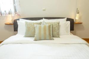 - un lit avec des draps et des oreillers blancs dans l'établissement XrysaHouse, à Artemi