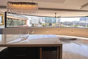 um copo de vinho sentado num balcão numa cozinha com uma janela em Luxury Penthouse In The Heart Of Sandton em Joanesburgo
