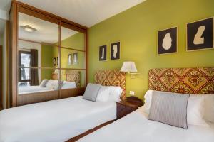 福米加尔Montesqui Formigal, exclusivo ático con vistas a pistas, guardaesquis y garaje的一间卧室配有两张白色的床和镜子