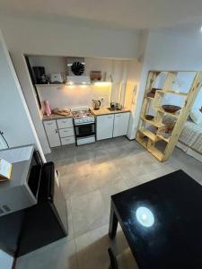 una pequeña cocina con fogones y mesa. en Departamento monoambiente Barrio Martin, en Rosario