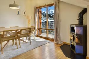 福米加尔Montesqui Formigal, exclusivo ático con vistas a pistas, guardaesquis y garaje的带桌子和木炉的餐厅