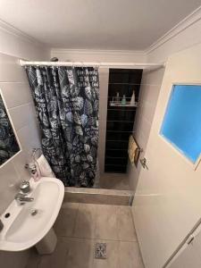 a bathroom with a sink and a shower curtain at Departamento monoambiente Barrio Martin in Rosario