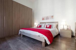 1 dormitorio con 1 cama grande con almohadas rojas en Testaccio Roma Style Apartment, en Roma