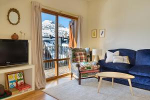 sala de estar con sofá azul y TV en Montesqui Formigal, exclusivo ático con vistas a pistas, guardaesquis y garaje, en Formigal