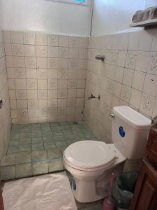 een badkamer met een toilet en een tegelvloer bij Mi Posada - La Cruz, Gte in La Cruz