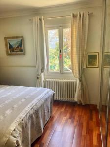 a bedroom with a bed and a window at Provencal house, sea side, private parking in Nice