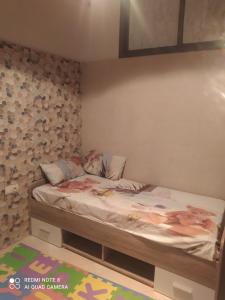 ein kleines Schlafzimmer mit einem Bett in der Ecke in der Unterkunft Duplex pour famille seulement in Fès