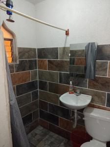 a bathroom with a sink and a toilet at Hotel y Restaurante Tzutujil in San Lucas Tolimán