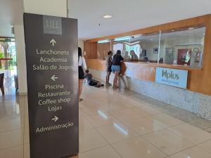 a sign in a mall with people waiting in line at Life Resort Flat - Torre F - Beira do lago in Brasília