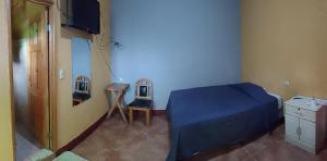 1 dormitorio con 1 cama, vestidor y TV en Hotel y Restaurante Tzutujil, en San Lucas Tolimán