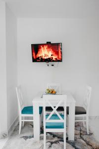 mesa blanca con 2 sillas y chimenea en Fantasia apartman-Divčibare, en Divčibare