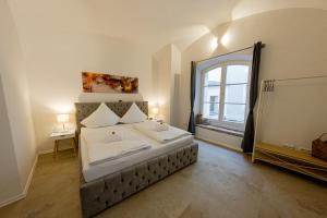 a bedroom with a bed and a large window at Servus Apartments Old Town Premium in Passau