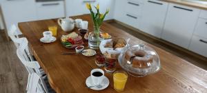 una mesa de madera con alimentos para el desayuno y bebidas. en Penzion pod Čeřinkem, en Mirošov