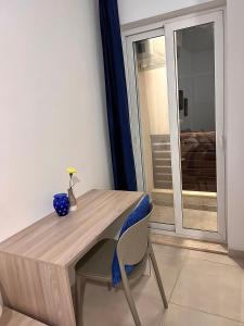 une table en bois et une chaise avec un vase bleu dans l'établissement Habitación Doble o sencilla en apartamento Compartido en Gzira Malta , zona centrica, à Il-Gżira