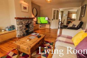 a living room with a couch and a fireplace at Skelligway Kenmare - Your Luxury Holiday Home in Kenmare