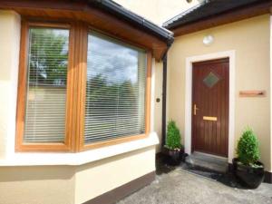a house with a wooden door and a window at Skelligway Kenmare - Your Luxury Holiday Home in Kenmare