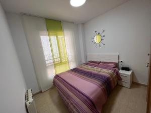 卡耐特蒂貝蘭格的住宿－Apartamento Canet d’en Berenguer，卧室配有一张床,墙上挂着一个钟