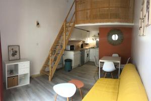 a kitchen and a living room with a loft at Appartement climatisé avec jardin et pkg privatif in Cap d'Agde