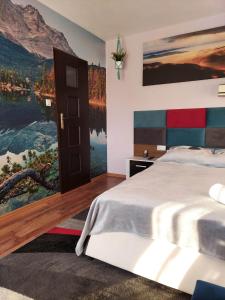a bedroom with a bed and a painting on the wall at Apartament i pokoje u Roberta in Polańczyk