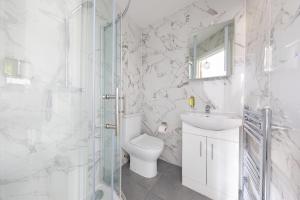 a bathroom with a toilet and a sink and a shower at Functional Budget Stay with Wi-Fi and Laundry Facilities near Tube Station in London