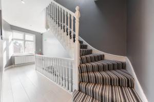 a staircase in a house with a rug at Functional Budget Stay with Wi-Fi and Laundry Facilities near Tube Station in London
